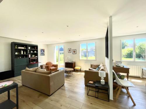 a living room with a couch and a table at Maison rénovée en centre-ville, à 5 min des plages in Beaussais sur Mer