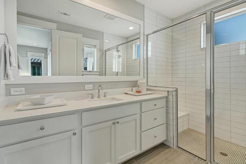 a white bathroom with a sink and a shower at Reserve at St Charles Bay Reserve Lane Townhome 202 in Rockport