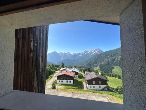 a view from a window of houses and mountains at HG Hotel La Caminatha in Val di Zoldo