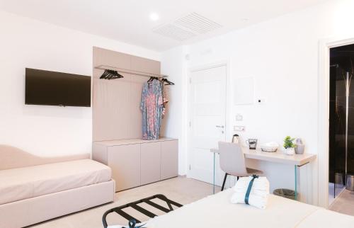 a white living room with a bed and a desk at Eleia Domos in Monopoli