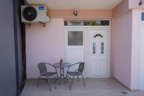 a table and chairs in a room with a door at Le Nina Apartments - Deluxe and Studio in Strumica