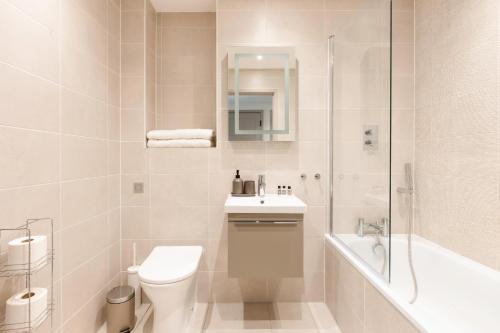 a bathroom with a toilet and a sink and a shower at Vespasian's Abode by Grandeur Property in Poole