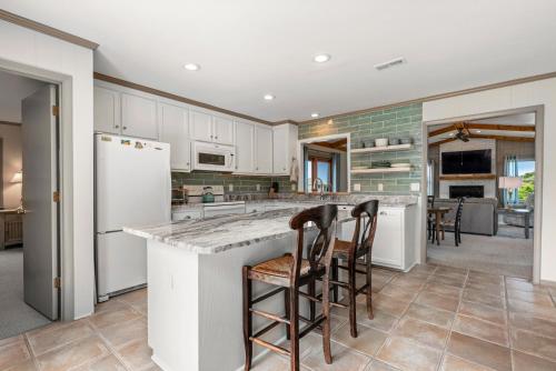 a kitchen with white cabinets and bar stools at The Mayors Nest in Duck