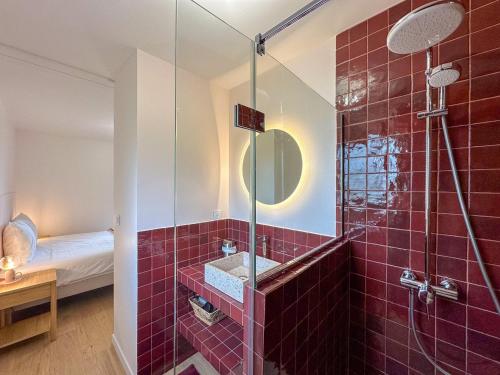 a red tile bathroom with a shower and a sink at Le Spot - Bain Nordique – Vue Cathédrale in Chartres