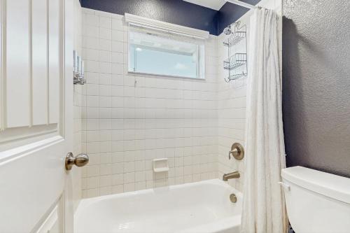 a bathroom with a white tub and a toilet at Paw and Peak Lodge in Colorado Springs