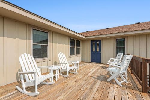 a deck with white chairs and a table on a house at The Mayors Nest in Duck