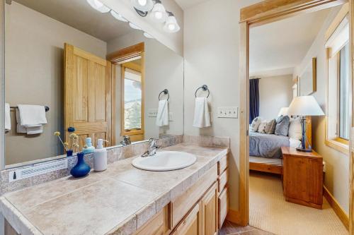 a bathroom with a sink and a large mirror at Moose Crossing at Town Center in Big Sky