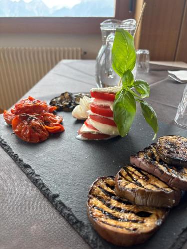 a table with a plate of food on a table at HG Hotel La Caminatha in Val di Zoldo