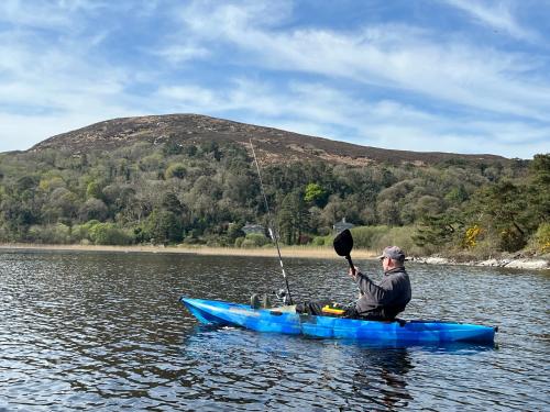 a man sitting in a blue kayak in the water at Lake View Doubleroom&private Bath in Castlebar