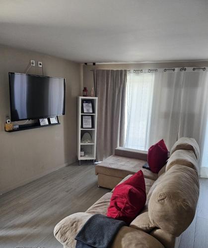 a living room with a couch and a flat screen tv at Casas Sebastião - Tourist House in Caminha