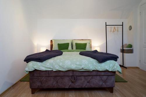 a bedroom with a bed with green pillows on it at Apartman dream in Novi Sad