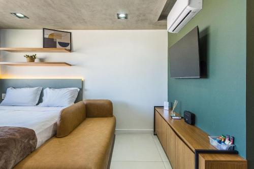 a bedroom with a bed and a flat screen tv at Novíssimo - Skyline Parque Moinhos in Porto Alegre