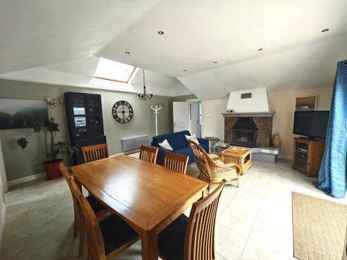 a dining room and living room with a wooden table at Charmante petite maison de campagne in Le Tréhou