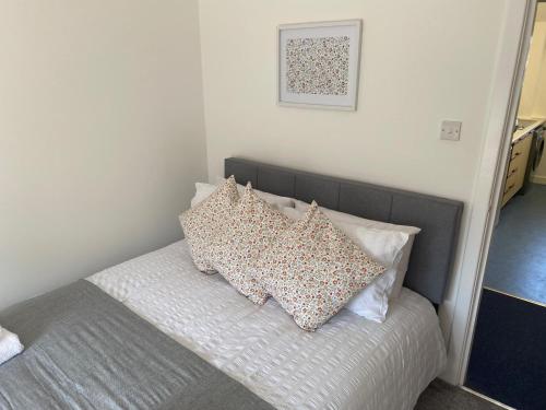 a bed with pillows on it in a bedroom at Glen Cannich - Top Location, 2BR Accessible apt in Inverkeithing
