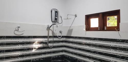 a shower in a bathroom with a window at Thilina Homestay in Sigiriya
