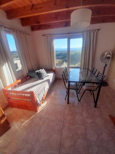 a bedroom with a table and a bed and a table and chairs at Ayres Serranos in Villa Carlos Paz
