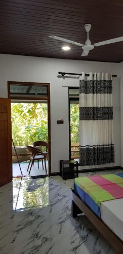 a bedroom with a bed and a sliding glass door at Thilina Homestay in Sigiriya