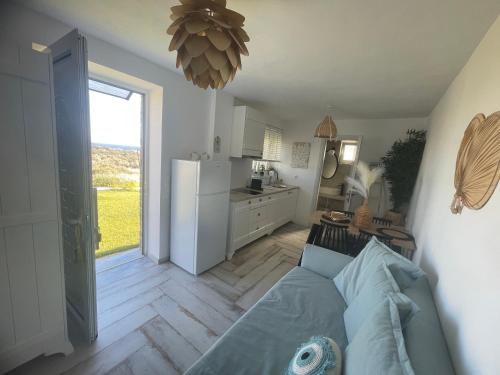 a living room with a blue couch and a kitchen at MIRAMAR KARYSTOS in Karistos