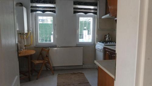 a kitchen with two windows and a table and a chair at White House in Sapanca