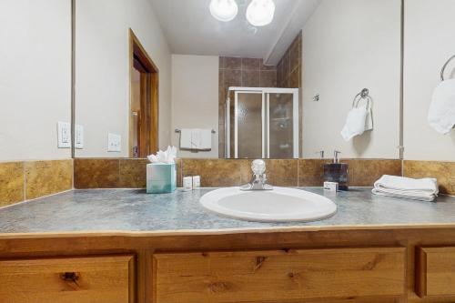 a bathroom with a sink and a large mirror at View House in Fraser