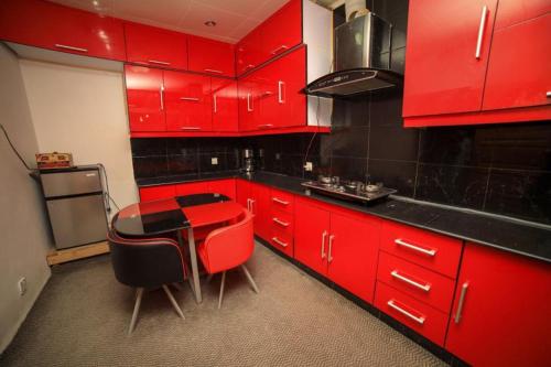a red kitchen with a table and red cabinets at BlueMoon villa in Skardu