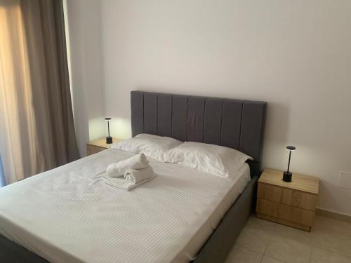 ein Schlafzimmer mit einem großen weißen Bett und zwei Nachttischen in der Unterkunft Vista Ionian in Sarandë