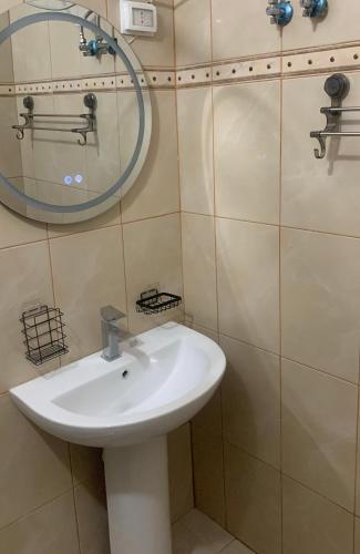 ein Badezimmer mit einem weißen Waschbecken und einem Spiegel in der Unterkunft Vista Ionian in Sarandë