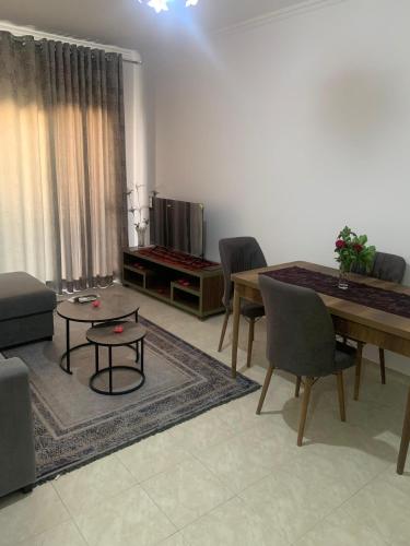 ein Wohnzimmer mit einem Tisch und ein Esszimmer in der Unterkunft Vista Ionian in Sarandë