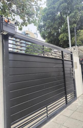 a black garage door with a metal fence at UrbanStay Flats in João Pessoa