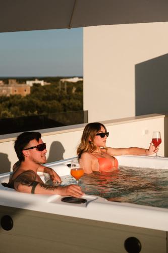 a man and woman sitting in a bath tub with wine at Eleia Domos in Monopoli