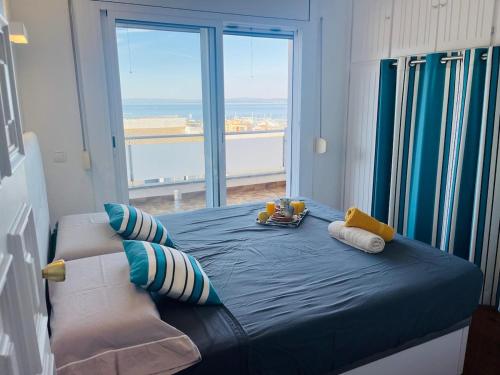 a bedroom with a blue bed with a large window at Costa Brava - Roses - Terrace & sea view in Roses