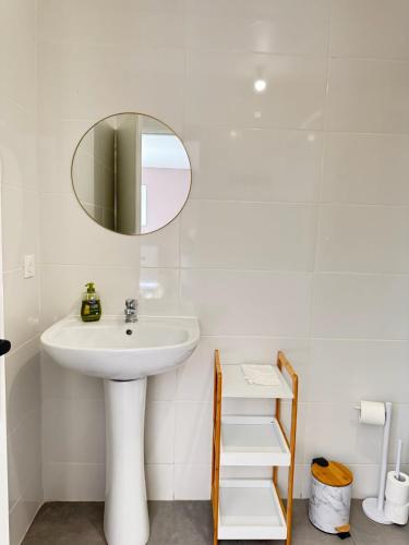 une salle de bain blanche avec un lavabo et un miroir dans l'établissement Studio B5 - Centre-Ville Meaux - Proche Disneyland, à Meaux