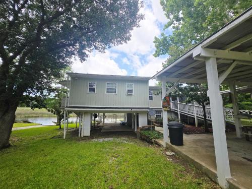 a gray house with a porch and a yard at The Lake House in Gautier