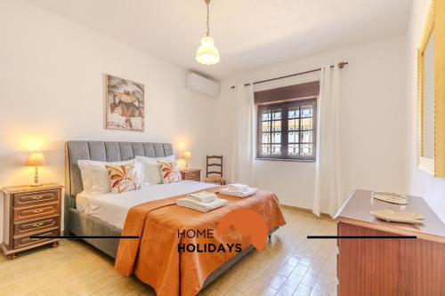 une chambre avec un lit avec un panneau de vacances dessus dans l'établissement #240 Beach House - Casa da Balaia by Home Holidays, à Olhos de Água