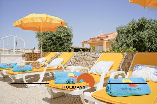 une rangée de chaises longues jaunes et un parasol dans l'établissement #240 Beach House - Casa da Balaia by Home Holidays, à Olhos de Água