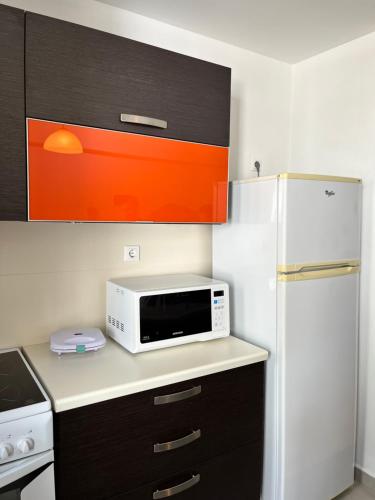 a kitchen with a microwave and a refrigerator at Annateli Suite in Ermoupoli