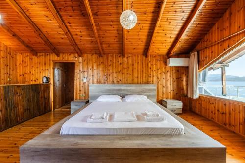 a bedroom with a large bed in a wooden room at Saranda Seaview Spot in Sarandë
