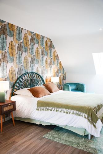 a bedroom with a bed with a large headboard at Jungle Room - Studio avec spa privé in Quéven