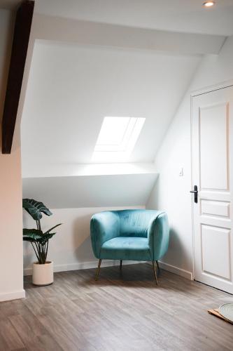 a blue chair in a room with a window at Jungle Room - Studio avec spa privé in Quéven