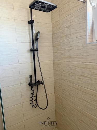 a shower in a bathroom with a shower head at Infinity Plaza Hotel in Gjakove