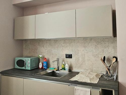 a kitchen counter with a sink and a microwave at Casa Matisse in Turin