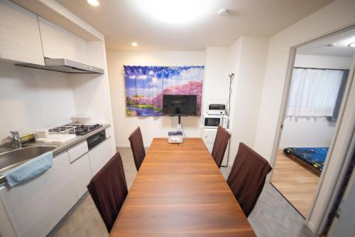 a kitchen with a long wooden table in a room at 桜屋Sakuraya101 in Tokyo