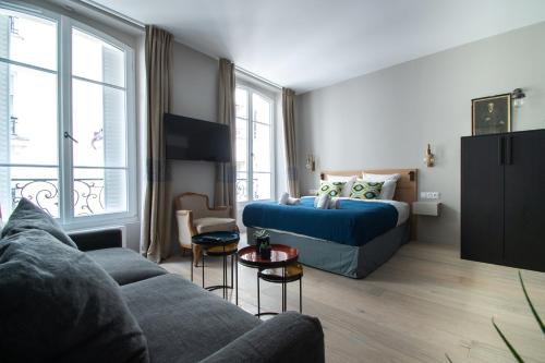 un soggiorno con un divano e un letto di Résidence du Louvre a Parigi