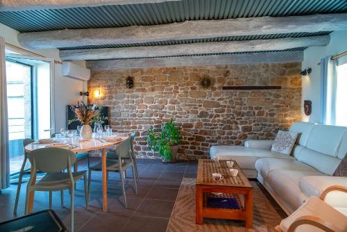 - un salon avec une table et un mur en briques dans l'établissement L'abri de Port Fétan - Vue mer, à Locmariaquer