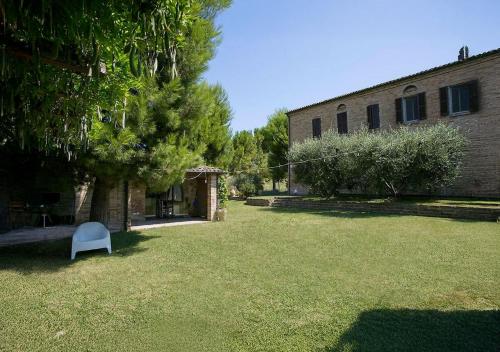 a yard with a white chair in front of a building at Villa Chloe in Potenza Picena