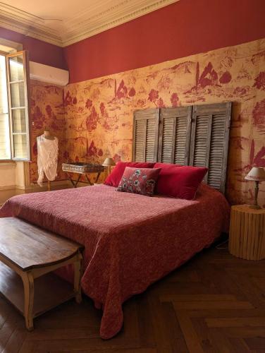 a bedroom with a large bed with red pillows at Le Clos de La Chardonnière in Saulce-sur-Rhône