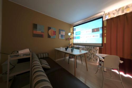 a living room with a couch and a large screen at Kamata332 蒲田駅の2LDKアパートメント 羽田8min 品川8min in Tokyo