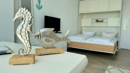 a statue of a fish on a table in a bedroom at Penthouse MEERblick, App 66 in Westerland (Sylt)