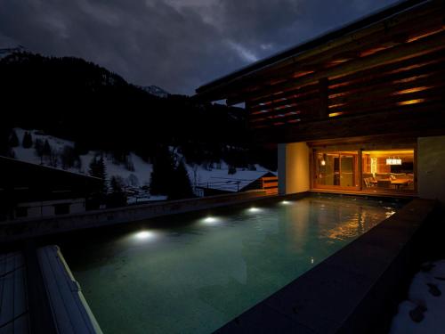 une piscine devant une maison la nuit dans l'établissement Chalet 5* à La Clusaz : piscine chauffée, skis aux pieds, 6 chambres, garage 3 voitures - FR-1-459-149, à La Clusaz