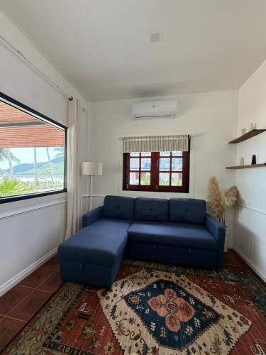 a blue couch in a living room with a window at Beachfront house in Chaloklum in Mae Haad